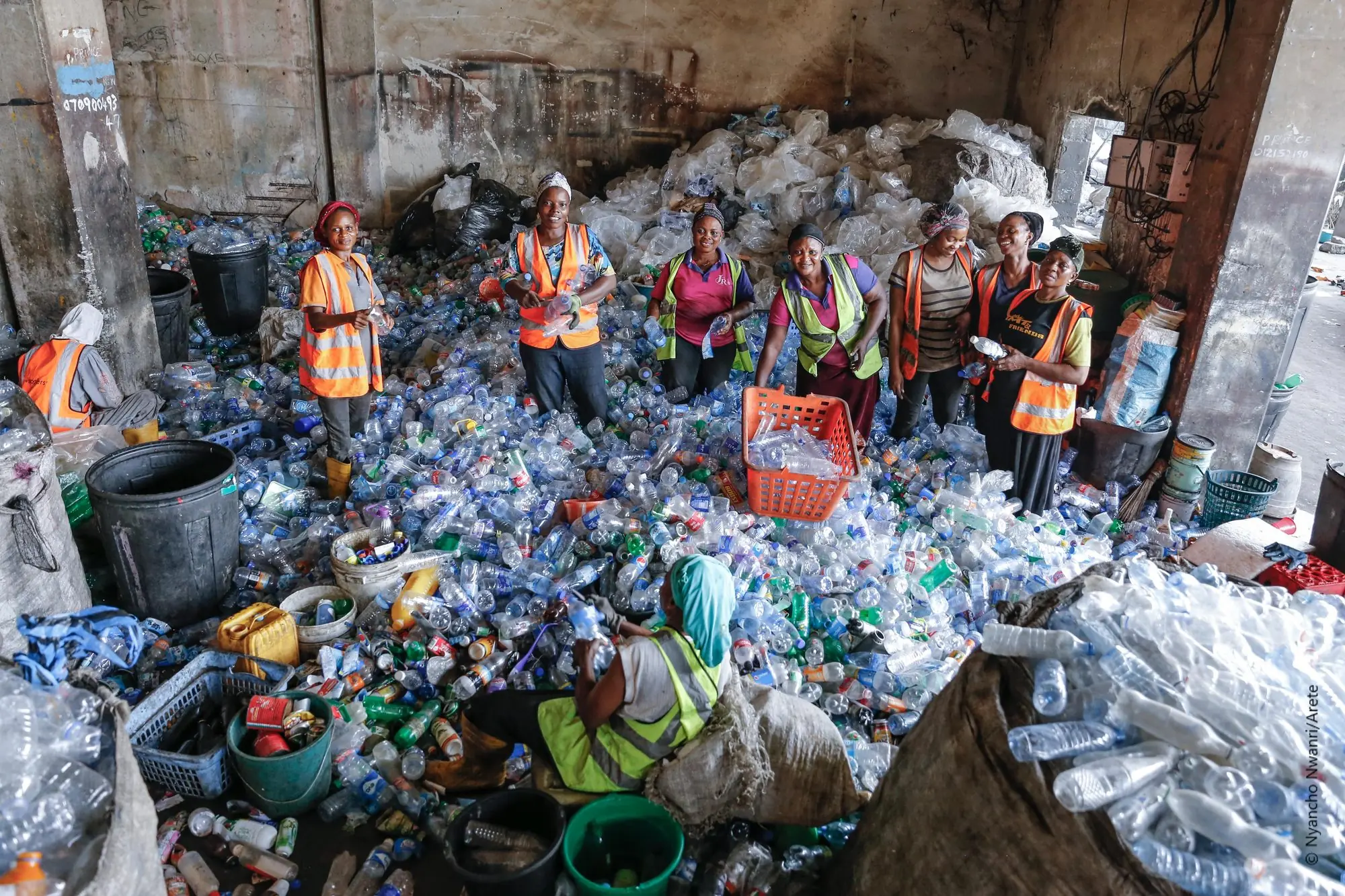 Community collectors sorting recovered plastic bottles at an urban recovery hub in West Africa